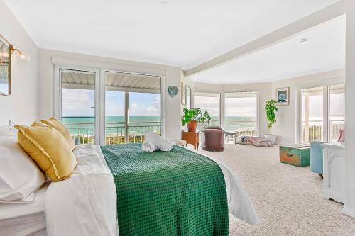 a bedroom with a bed and views of the ocean at Arcadia Beachfront Retreat in Mandurah