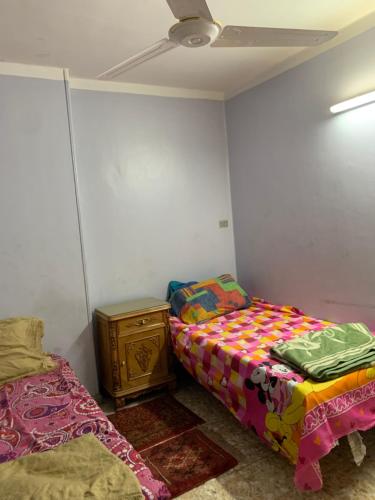 - une chambre avec deux lits, une commode et un plafond dans l'établissement Azzam Guest House 1 families only, à Fayoum