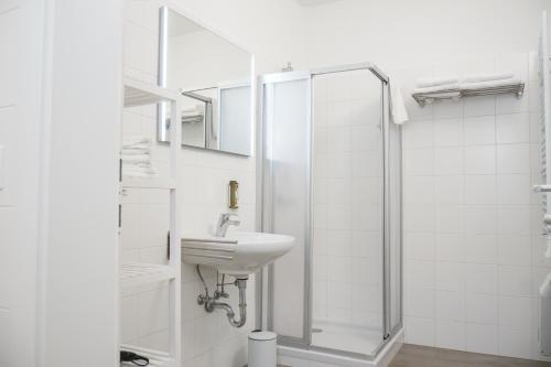 y baño blanco con lavabo y ducha. en Chill & Relax Apartments Purbach en Purbach am Neusiedlersee