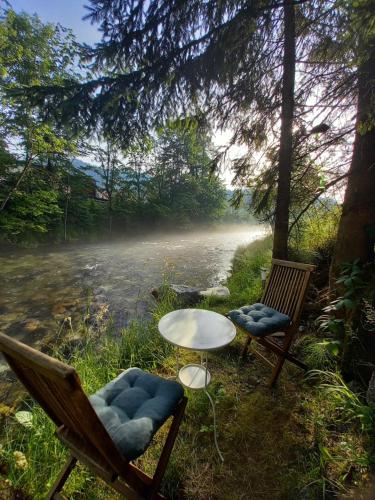 two chairs and a table next to a road at The RiverSide Chill Hostel in Zgornje Gorje