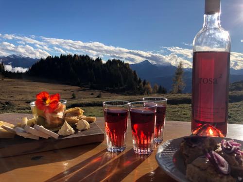 Feldis的住宿－Alp Jurte Skihütte Feldis，一张桌子,上面放着两杯酒和一瓶葡萄酒