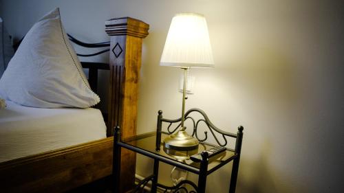 a lamp on a side table next to a bed at Hafen 12 in Bremerhaven
