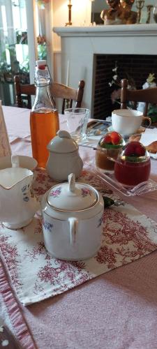 einen Tisch mit einem Tischtuch und einem Tee-Set darauf in der Unterkunft Le Clos des Roses in Parçay-les-Pins