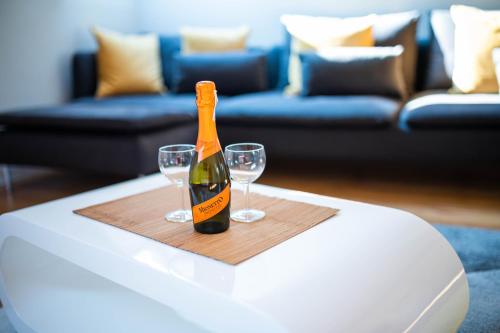 Una botella de champán y dos copas en una mesa. en Apartamenty Wielbarska, en Szczytno