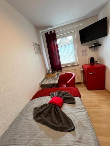 ザルツギッターにあるPension K.Krauseのベッドルーム1室(ベッド1台、赤い椅子付)