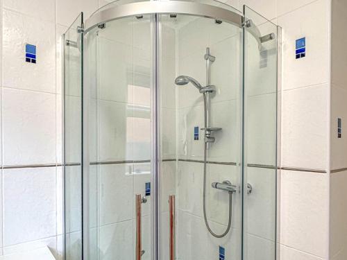 eine Dusche mit Glastür im Bad in der Unterkunft Squires Bungalow in Gunton