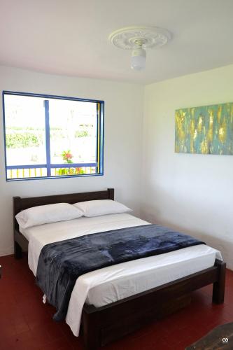 a bedroom with a large bed with a window at San Antonio in Quimbaya