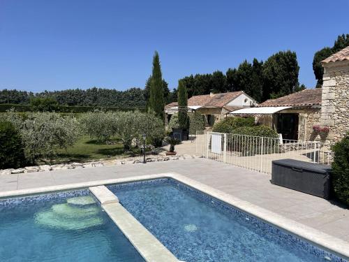 a swimming pool in a yard with a house at Le Mas Des Chutes in Graveson