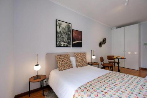 a bedroom with a bed and two tables and chairs at Impar Studios Deluxe in Porto