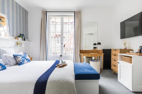 a hotel room with a bed and a television at Le Flaubert in Trouville-sur-Mer