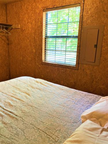 a bedroom with a bed and a window at Outback Campground and Marina in Trinity