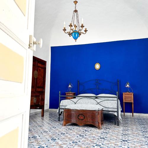 Dormitorio azul con cama y lámpara de araña en Tenuta Nunziata - food, event, biofarm, en Torre Annunziata