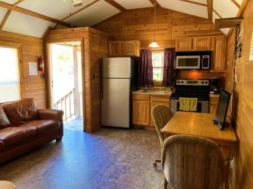a kitchen with a refrigerator and a table with chairs at Outback Campground and Marina in Trinity