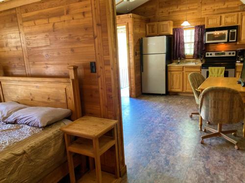 a kitchen with a bed and a table and a refrigerator at Outback Campground and Marina in Trinity