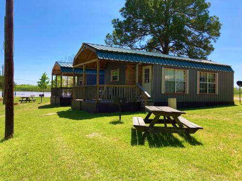 a cabin with a picnic table in front of it at Outback Campground and Marina in Trinity