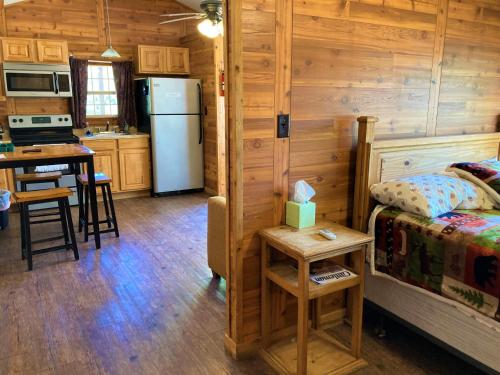 a kitchen and a bedroom with a refrigerator and a table at Outback Campground and Marina in Trinity