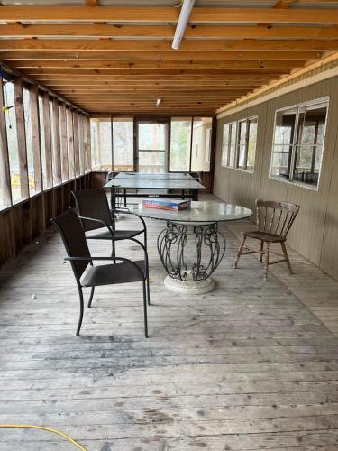 a screened porch with a ping pong table and chairs at Outback Campground and Marina in Trinity