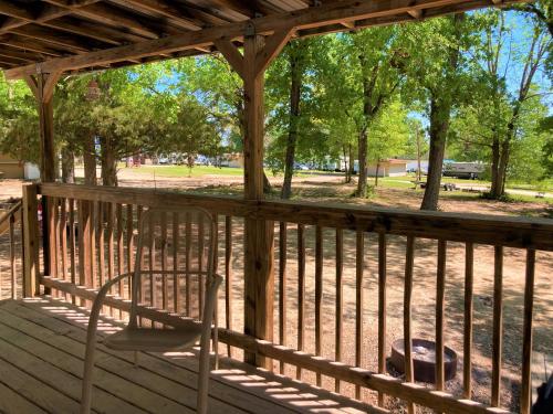 a wooden porch with a chair on a deck at Outback Campground and Marina in Trinity