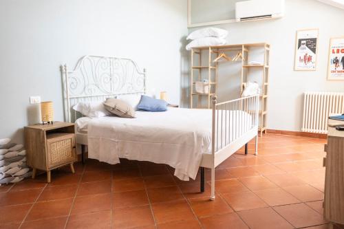 a bedroom with a white bed and a tiled floor at Palazzo Oddo Rental Rooms in Albenga