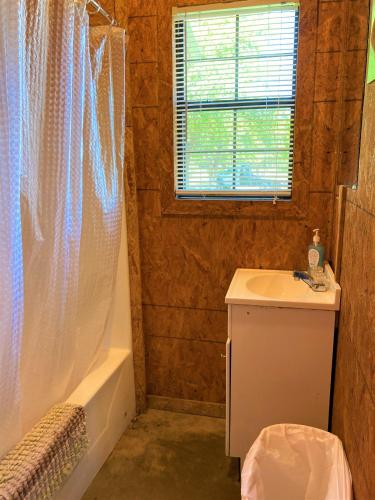 a bathroom with a sink and a shower curtain at Outback Campground and Marina in Trinity