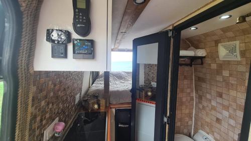 eine Küche mit einem Kühlschrank und einer Uhr an der Wand in der Unterkunft Camperlife in Tbilisi City