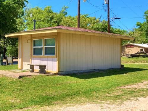 a small house with a bench in the grass at Outback Campground and Marina in Trinity