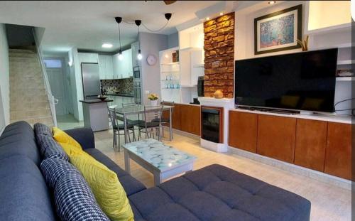 a living room with a couch and a large television at Balcón Atlantida in Candelaria