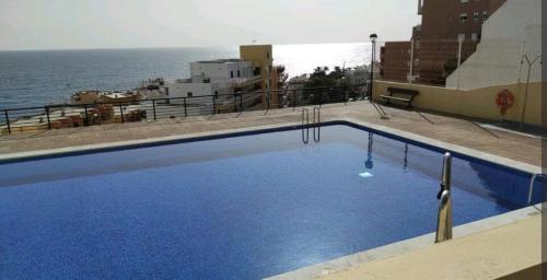 a swimming pool on top of a building with the ocean at Balcón Atlantida in Candelaria