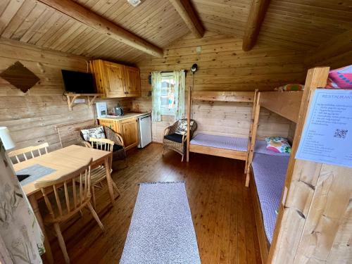 a cabin with a bunk bed and a dining room at Gullvåg Camping Nyberg in Soknedal