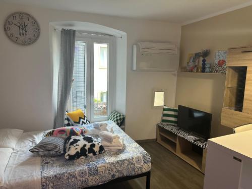 ein Schlafzimmer mit einem Bett und einer Uhr an der Wand in der Unterkunft FEEL - Vivid Apartment in Bergamo