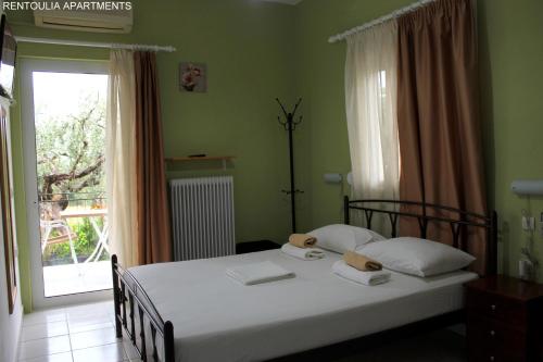 a bedroom with a bed and a window with a door at Rentoulia Apartments in Poulithra