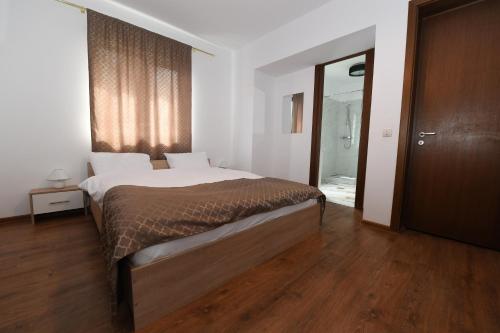a bedroom with a large bed and a wooden floor at Casa cu Scări in Lunca Mare