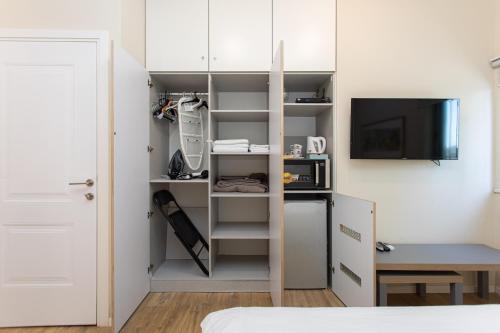 a small room with a bed and a room with a microwave at Hanasi 129 - Boutique Apartments in Haifa