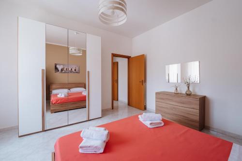um quarto com uma cama vermelha e um espelho em Angolo 31 em Trapani