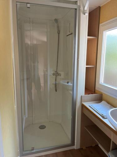 une douche avec une porte vitrée dans une salle de bain dans l'établissement Gites de la Massane, à Argelès-sur-Mer