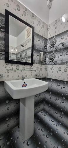 a bathroom with a sink and a mirror at Nilaveli Guest House in Nilaveli