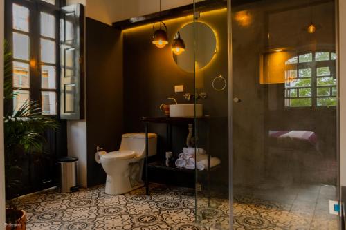 uma casa de banho com um WC e uma cabina de duche em vidro. em La Banksia Hotel em Quito