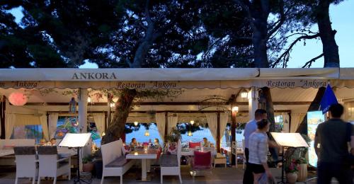 a group of people standing in front of a tent with tables at Beach Apartments Ankora in Makarska