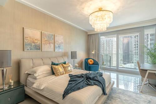 Un dormitorio con una cama grande y una lámpara de araña. en Spectacular Views of Burj & Fountain - 2 BR, en Dubái