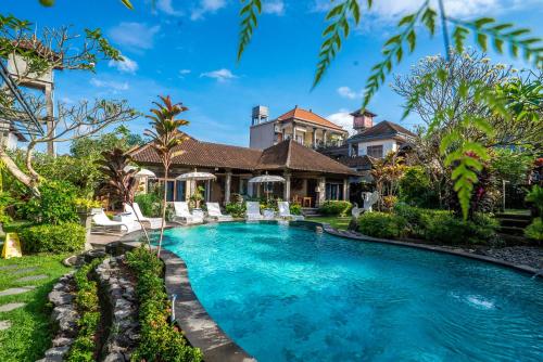 a swimming pool in front of a house at Capung Cottages in Ubud
