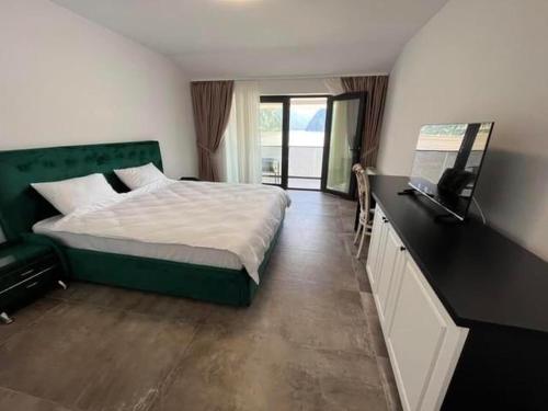 a bedroom with a large bed and a window at Pensiunea PHILIA in Dubova