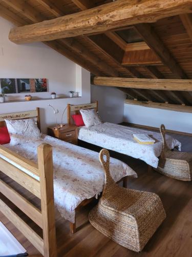 two beds in a room with wooden ceilings at LA CARABA 