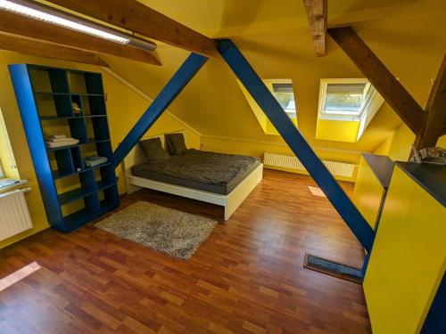 - une chambre aux murs jaunes et un lit dans un dortoir dans l'établissement Anton's bunte Welt (100 m², Parkplatz, Garten und viel mehr), à Albersdorf