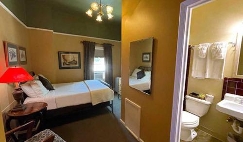 Habitación pequeña con 2 camas y baño. en Weatherford Hotel en Flagstaff