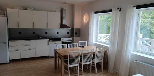 cocina con mesa de madera y armarios blancos en Hällevadsholm, en Hällevadsholm