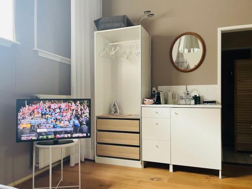 een kamer met een tv en een witte kast bij Kerkstraatje3 in Zutphen