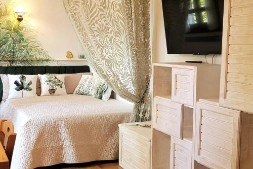 a small bedroom with a bed and a tv at Presolana Suite in Love casa vacanza in Castione della Presolana
