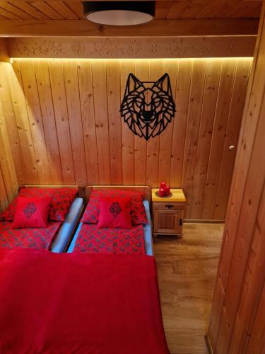 Cette chambre comprend 2 lits et une tête de chat sur le mur. dans l'établissement Willa Zacisze, à Zakopane
