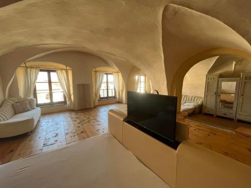 Residence Spillenberg Bridal Suite - Svadobna cesta في ليفوتشا: غرفة معيشة كبيرة مع أريكة وتلفزيون