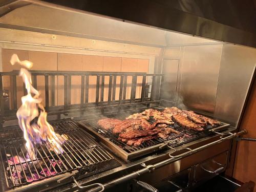 - un grill avec de la viande au-dessus dans l'établissement Grotto del Pan Perdü, à Carona
